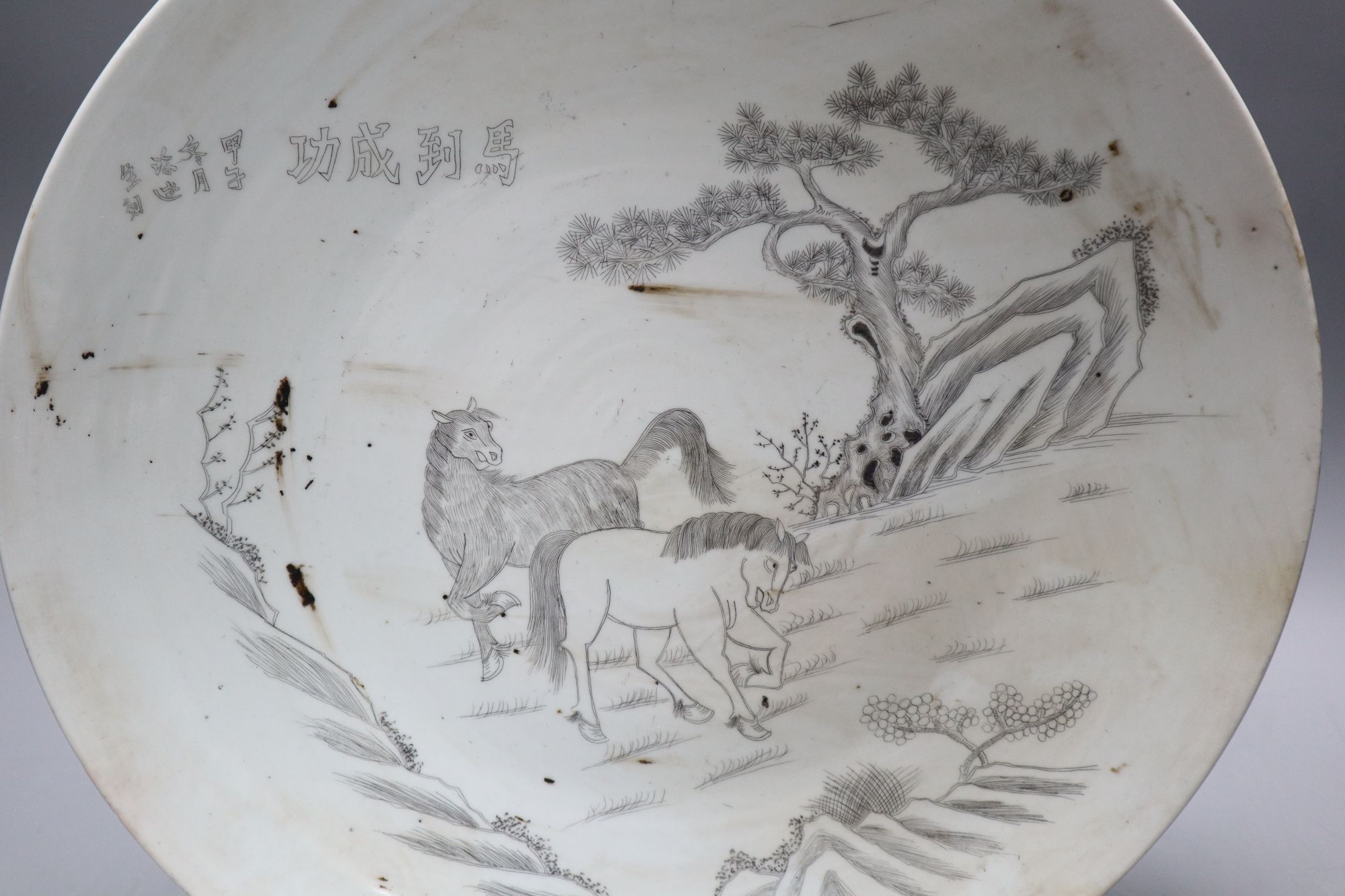 A Chinese porcelain dish engraved with horses, rocks and pine, diameter 33.5cm
